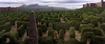 Movie still from “Labyrinth” (1986), directed by Jim Henson – A man and a woman are walking through a hedge maze; Extreme Wide shot, High angle