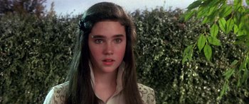 Movie still from “Labyrinth” (1986), directed by Jim Henson – A young woman with long brown hair wearing a white shirt; Close Up shot, Over the shoulder angle