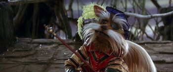 Movie still from “Labyrinth” (1986), directed by Jim Henson – A dog dressed up like a musketeer holding a sword; Close Up shot, High angle