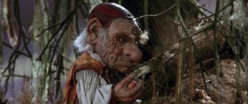 Movie still from “Labyrinth” (1986), directed by Jim Henson – An old man dressed as a gnome eating an apple; Close Up shot, Low angle