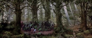 Movie still from “Labyrinth” (1986), directed by Jim Henson – Two people are standing in the woods near trees; Extreme Wide shot, Low angle