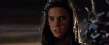 Movie still from “Labyrinth” (1986), directed by Jim Henson – A woman with long dark hair is looking at the camera; Close Up shot, Over the shoulder angle