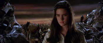 Movie still from “Labyrinth” (1986), directed by Jim Henson – A young woman with long dark brown hair looking to her left; Close Up shot, Over the shoulder angle