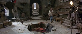 Movie still from “Labyrinth” (1986), directed by Jim Henson – A woman standing in front of an open hole in the ground; Wide shot, High angle