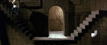 Movie still from “Labyrinth” (1986), directed by Jim Henson – An archway in the middle of a stone staircase; Wide shot, High angle
