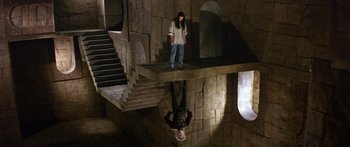 Movie still from “Labyrinth” (1986), directed by Jim Henson – A man hanging upside down on a platform; Wide shot, Overhead angle