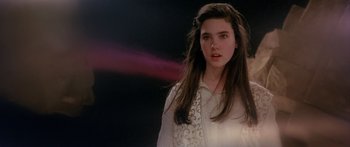 Movie still from “Labyrinth” (1986), directed by Jim Henson – A young woman in a white shirt is looking at the camera; Close Up shot, Over the shoulder angle