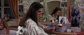 Movie still from “Labyrinth” (1986), directed by Jim Henson – A woman sitting in front of a mirror with makeup products on it; Medium shot, High angle