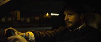 Movie still from “Locke” (2013), directed by Steven Knight – A man sitting in the back seat of a car at night; Close Up shot, Over the shoulder angle
