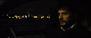 Movie still from “Locke” (2013), directed by Steven Knight – A man sitting in the driver's seat of a car at night; Close Up shot, Over the shoulder angle