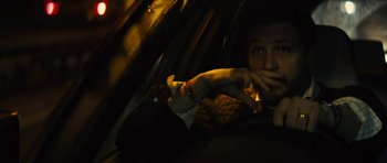 Movie still from “Locke” (2013), directed by Steven Knight – A man sitting in a car at night with his hand up to his mouth; Close Up shot, Over the shoulder angle