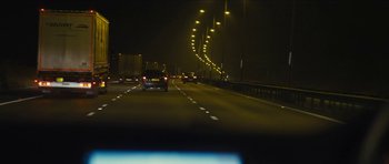 Movie still from “Locke” (2013), directed by Steven Knight – Cars driving down a highway at night with lights on; Extreme Wide shot, High angle