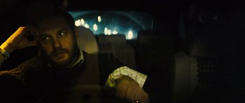 Movie still from “Locke” (2013), directed by Steven Knight – A man sitting in the back seat of a car at night; Close Up shot, Over the shoulder angle
