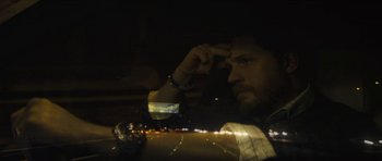 Movie still from “Locke” (2013), directed by Steven Knight – A man sitting in a car at night looking at his phone; Close Up shot, Over the shoulder angle