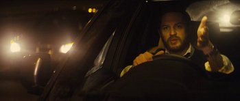 Movie still from “Locke” (2013), directed by Steven Knight – A man sitting in the driver's seat of a car at night; Close Up shot, Low angle