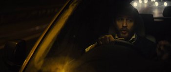 Movie still from “Locke” (2013), directed by Steven Knight – A man holding a toothbrush in a car; Close Up shot, Low angle