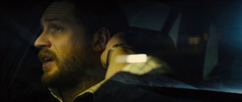 Movie still from “Locke” (2013), directed by Steven Knight – A man wearing a yellow shirt and a black jacket; Close Up shot, Over the shoulder angle