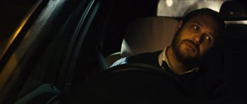 Movie still from “Locke” (2013), directed by Steven Knight – A person sitting in the driver's seat of a car; Close Up shot, Over the shoulder angle