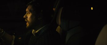 Movie still from “Locke” (2013), directed by Steven Knight – A man sitting in the driver's seat of a car at night; Close Up shot, Over the shoulder angle