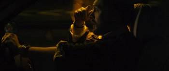 Movie still from “Locke” (2013), directed by Steven Knight – A man sitting in a dark room holding a cell phone to his ear; Close Up shot, Low angle