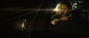 Movie still from “Locke” (2013), directed by Steven Knight – A man sitting in the back seat of a car at night; Close Up shot, Over the shoulder angle