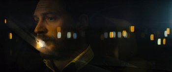 Movie still from “Locke” (2013), directed by Steven Knight – A man with a beard is looking out a window; Close Up shot, Over the shoulder angle