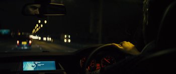 Movie still from “Locke” (2013), directed by Steven Knight – A person is driving a car at night time; Close Up shot, Over the shoulder angle