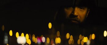 Movie still from “Locke” (2013), directed by Steven Knight – A blurry picture of a man's face with lights in the background; Extreme Close Up shot, Over the shoulder angle