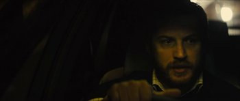 Movie still from “Locke” (2013), directed by Steven Knight – A man driving a car in the dark at night; Close Up shot, Over the shoulder angle