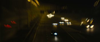 Movie still from “Locke” (2013), directed by Steven Knight – A car driving down a street at night with lights on; Extreme Wide shot, High angle