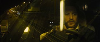 Movie still from “Locke” (2013), directed by Steven Knight – A man looking out of a window at night; Close Up shot, High angle