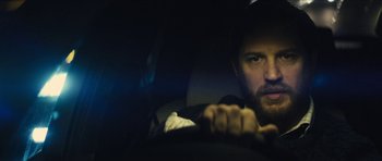 Movie still from “Locke” (2013), directed by Steven Knight – A man driving in a car at night; Close Up shot, Over the shoulder angle
