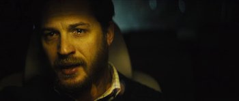 Movie still from “Locke” (2013), directed by Steven Knight – A person with a beard in a car; Close Up shot, Over the shoulder angle