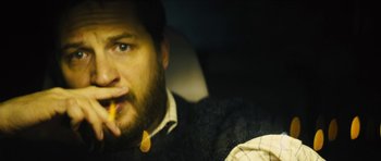 Movie still from “Locke” (2013), directed by Steven Knight – A person eating a piece of food; Close Up shot, Over the shoulder angle