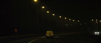Movie still from “Locke” (2013), directed by Steven Knight – A car driving down a dark road at night; Extreme Wide shot, Low angle