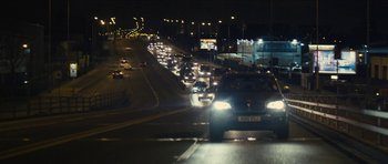 Movie still from “Locke” (2013), directed by Steven Knight – A bunch of cars that are on the street at night; Extreme Wide shot, Over the shoulder angle