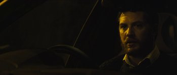 Movie still from “Locke” (2013), directed by Steven Knight – A man sitting in the driver's seat of a car; Close Up shot, Over the shoulder angle