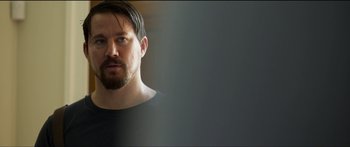 Movie still from “Logan Lucky” (2017), directed by Steven Soderbergh – A person wearing a black shirt; Close Up shot, Over the shoulder angle