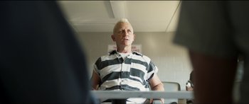 Movie still from “Logan Lucky” (2017), directed by Steven Soderbergh – An older man in a prison uniform sitting in a chair; Medium shot, Over the shoulder angle