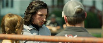 Movie still from “Logan Lucky” (2017), directed by Steven Soderbergh – A man with long dark hair is talking to another man in a baseball cap; Close Up shot, Over the shoulder angle