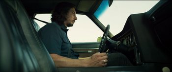 Movie still from “Logan Lucky” (2017), directed by Steven Soderbergh – A man sitting in the driver's seat of a car; Medium shot, Low angle