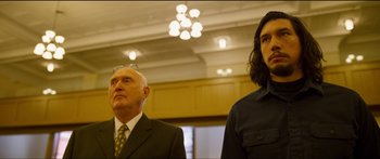 Movie still from “Logan Lucky” (2017), directed by Steven Soderbergh – A man and a woman standing next to each other in a room; Medium shot, Low angle