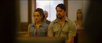 Movie still from “Logan Lucky” (2017), directed by Steven Soderbergh – A man and a woman sitting next to each other in a courtroom; Medium shot, Over the shoulder angle