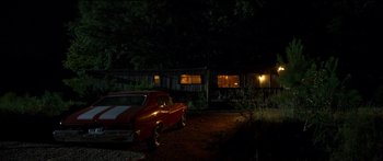 Movie still from “Logan Lucky” (2017), directed by Steven Soderbergh – A red car parked in front of a house at night; Extreme Wide shot, Low angle