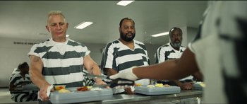 Movie still from “Logan Lucky” (2017), directed by Steven Soderbergh – A group of men in striped shirts preparing food; Medium shot, Over the shoulder angle