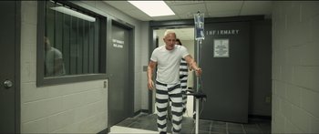Movie still from “Logan Lucky” (2017), directed by Steven Soderbergh – A man in prison garb walking down a hallway; Wide shot, High angle