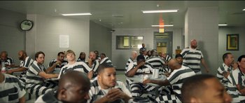 Movie still from “Logan Lucky” (2017), directed by Steven Soderbergh – A large group of people in prison uniforms eating; Extreme Wide shot, High angle