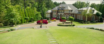 Movie still from “Logan Lucky” (2017), directed by Steven Soderbergh – A large driveway with cars parked in front of a house; Extreme Wide shot, High angle