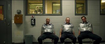 Movie still from “Logan Lucky” (2017), directed by Steven Soderbergh – A couple of men sitting next to each other wrapped in duct tape; Wide shot, Low angle