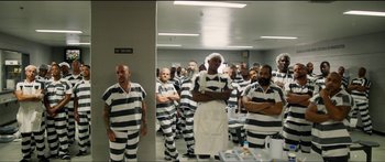 Movie still from “Logan Lucky” (2017), directed by Steven Soderbergh – A group of men in prison uniforms standing in a room; Wide shot, High angle
